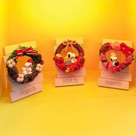 Close-up of three Snoopy and Peanuts wreath figurines with festive decorations, gallery position 1 zoom image