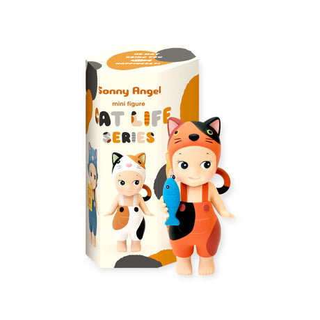 A limited edition toy figurine from the Sonny Angel brand, dressed in a cat costume and holding a fish, is positioned beside a box labeled "Sonny Angel Cat Life Series - Blind Box.