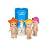 Three figures from the Sonny Angel Marine Series, featuring ocean-inspired hats like starfish, fish, and shark, stand near their blue packaging. Each figure is a delightful mystery from the Sonny Angel brand meant to brighten your day.