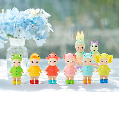 Seven pastel character figurines in animal hood rain outfits in a row