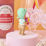 Sonny Angel Summer Vacation Sun Kissed figurine holding a pink drink can on white pedestal