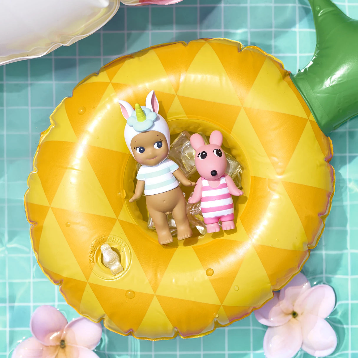 Sonny Angel Summer Vacation Sun Kissed figurines inside yellow pool float, hugging rabbit plush