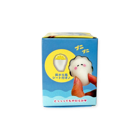Side view of Squishy Oyster Blind Box showing soft oyster toy with lemon slice on blue packaging background