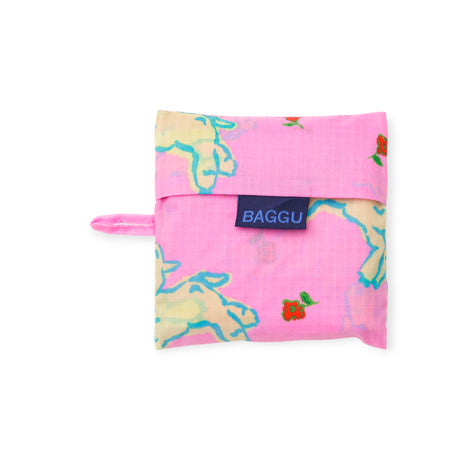 Folded pink pouch with light yellow lamb and small red flower pattern and navy BAGGU label on white background