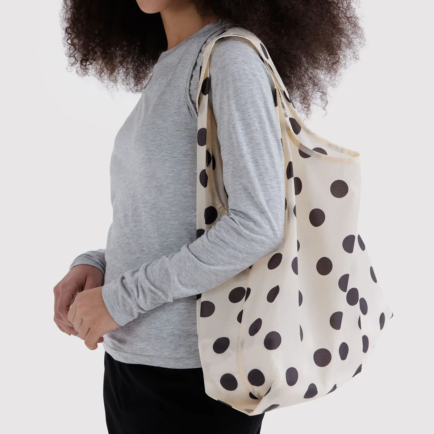 Cream polka-dot tote bag carried by strap, large black dots, open roomy shape