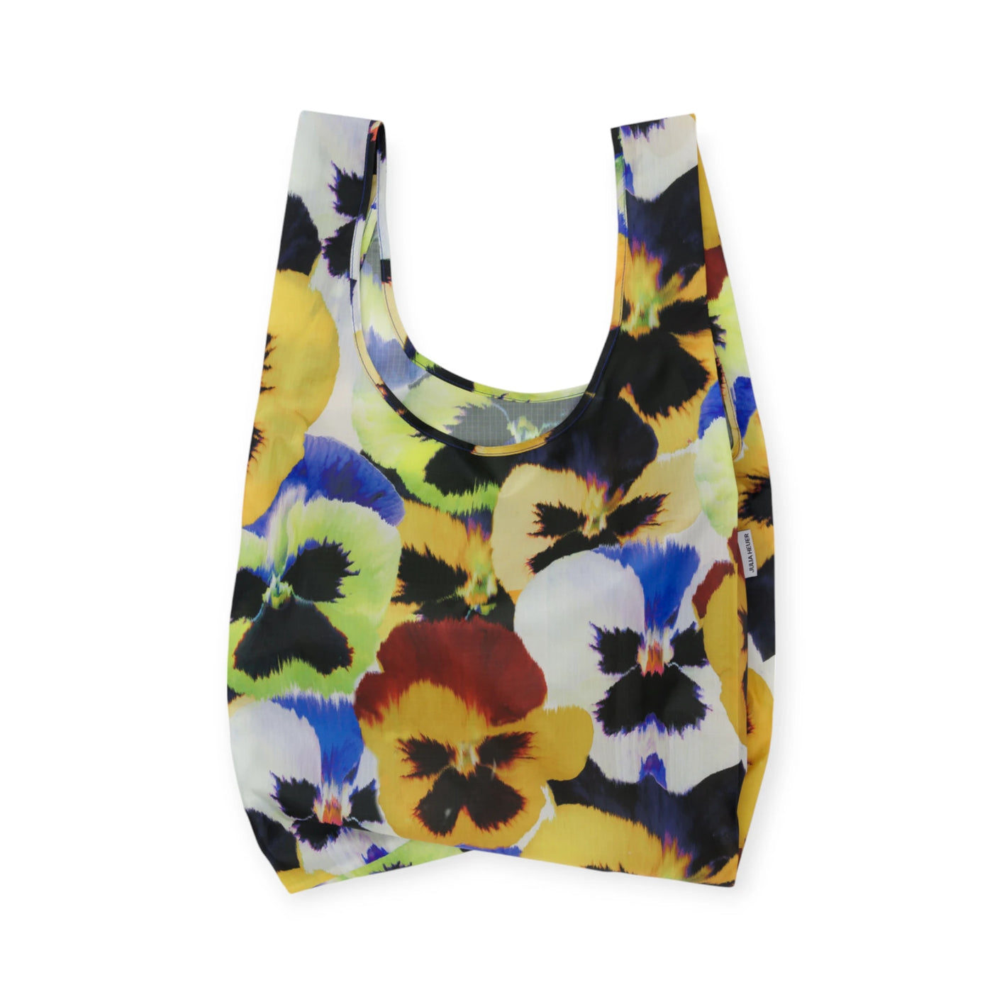 The Standard Baggu x Julia Heuer - Pansy is a reusable shopping bag featuring a vibrant pansy pattern on a white background, made from recycled nylon. This collaboration between Baggu and Julia Heuer offers sustainable materials with a striking design.