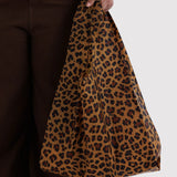 Baggu leopard print tote bag with long shoulder straps, held in hand