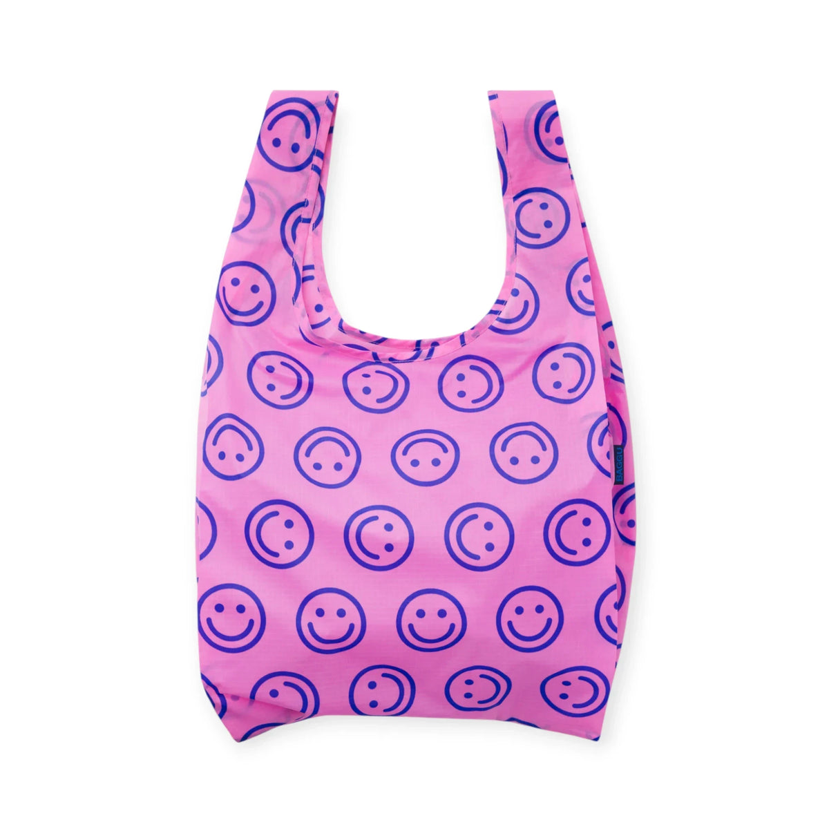 Pink cloth tote bag with repeating smiley face pattern and wide open top.