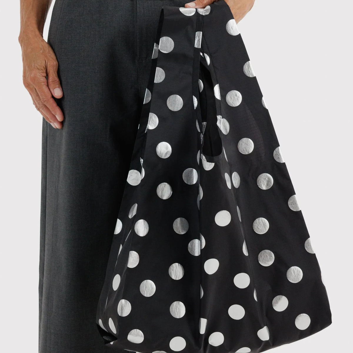 Baggu polka-dot tote bag worn on shoulder, black with silver dots