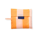 The Baggu Standard Reusable Bag in Tangerine Stripe is adorned with vibrant tangerine stripes and includes a handy carrying strap, accented by a navy Baggu label on the front.