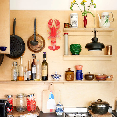 3D lobster wall art puzzle mounted on wooden kitchen wall surrounded by vintage cookware and bottles