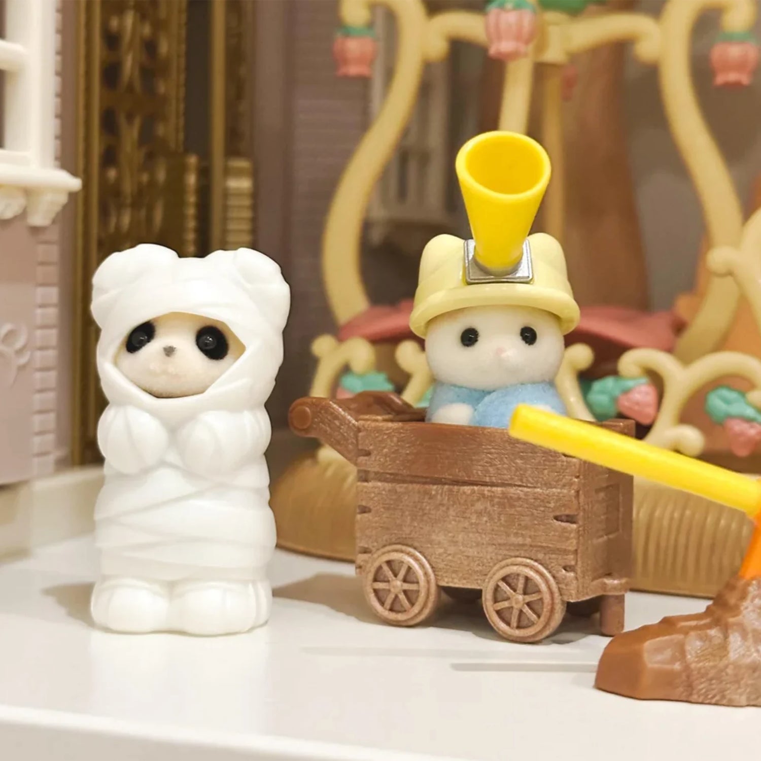 White hooded animal figurine with brown wagon and yellow handle