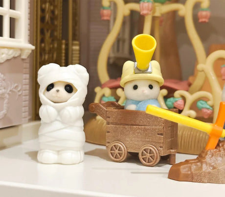 White hooded animal figurine with brown wagon and yellow handle