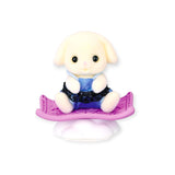 Cute baby rabbit figure in blue vest, sitting on a purple stand.
