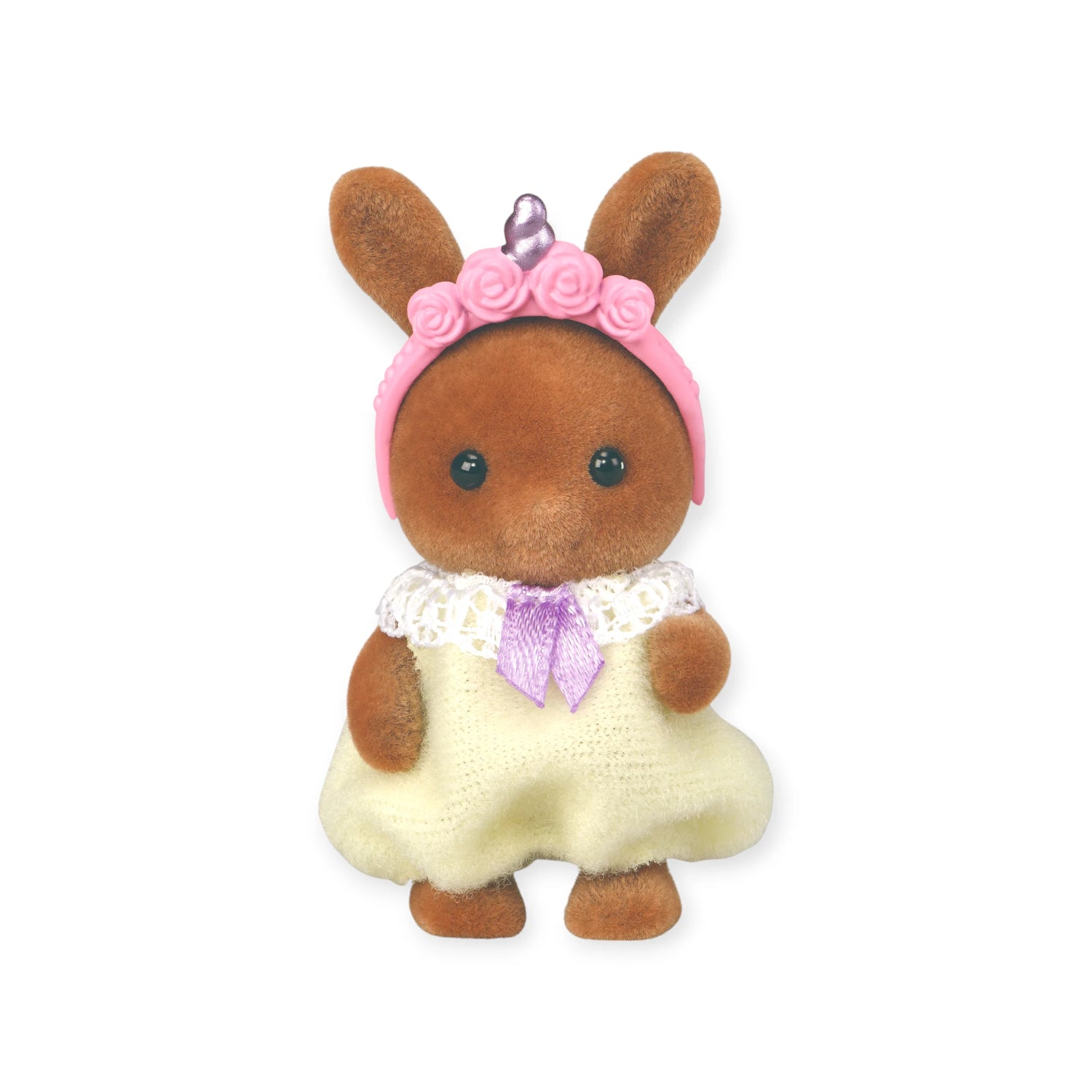 A brown Sylvanian Families Blind Bag - Baby Fun Hair bunny toy from Sylvanian Families, dressed in a cream dress with a purple bow and pink headband with roses and a purple gem, stands upright against a white background.
