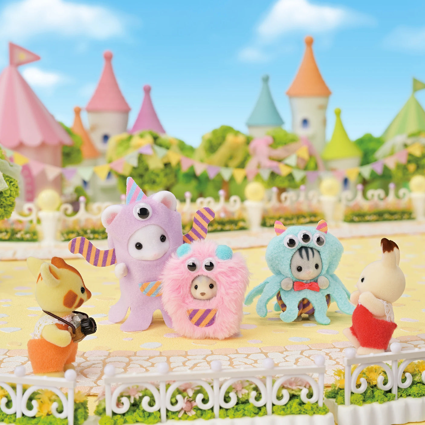 Sylvanian Families - Funny Monster Trio showing three small plush characters in colorful monster costumes with moving goggle eyes outdoors.