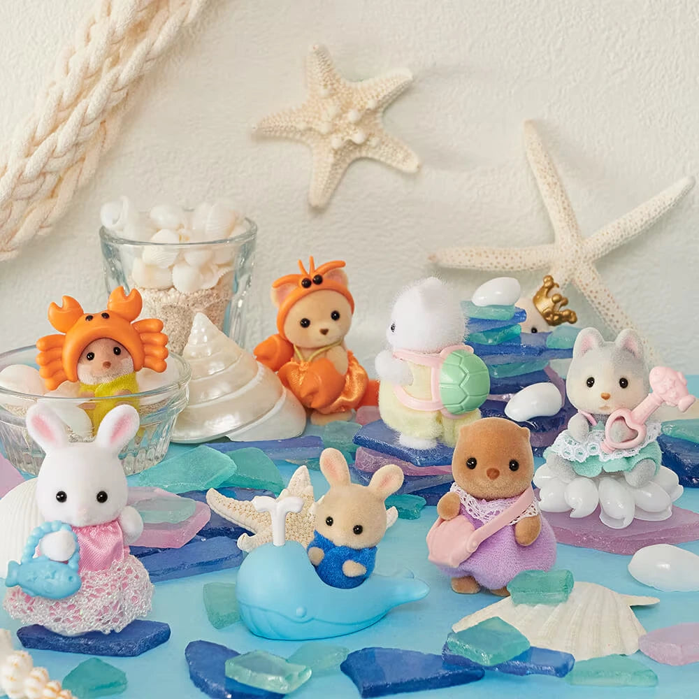 Sylvanian Families Blind Bag - Baby Seashore Friends Series by Sylvanian Families features adorable babies in colorful seaside outfits, displayed with sea shells, glass pieces, and starfish for a charming ocean-themed scene.