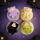 Teddy LuLu - Whispers of Nature Plush Charm - Blind Box showing four LuLu The Piggy plush charms in pastel teddy suits on colored cushions