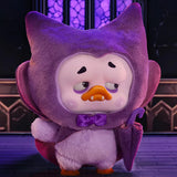Upset Duck Blind Box - Colourful Player Plush Keychain showing a tired duck in a purple monster costume holding a small umbrella by Upset Duck
