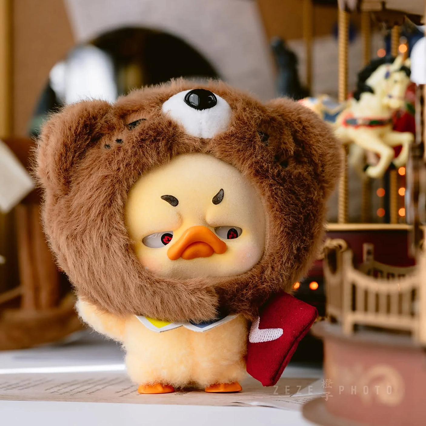 Brown plush duck with white eye patch and black-and-brown hood, wearing red boots