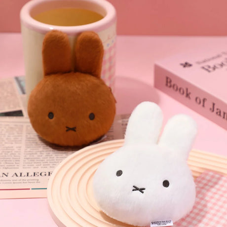 White plush bunny pouch keychain with metal ring, beside brown bunny plush
