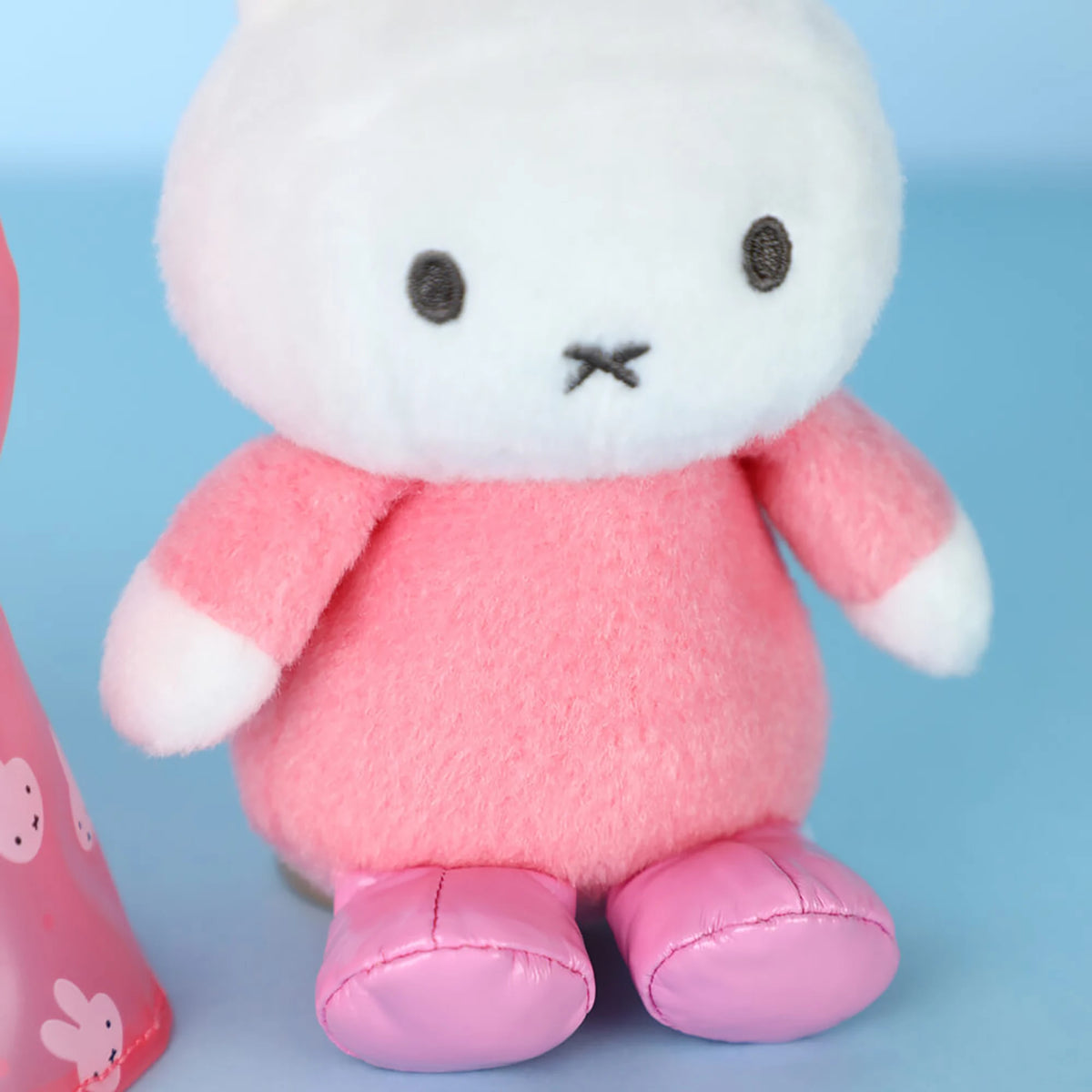 White plush rabbit with pink body, embroidered eyes, and small stitched mouth