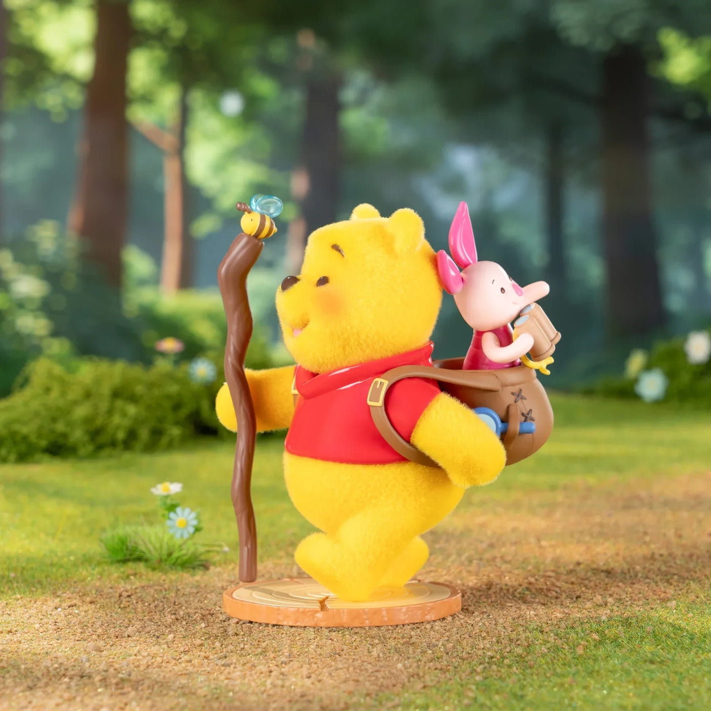 Winnie the Pooh figurine holding a small bottle and a pink rabbit accessory