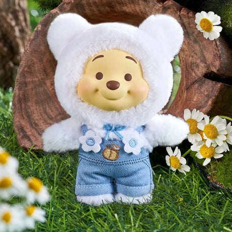 Winnie the Pooh Candy Bear vinyl plush in white fuzzy bear costume with denim overalls and flower details on grass