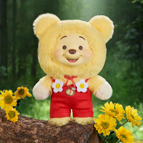 Winnie the Pooh Candy Bear vinyl plush in yellow fuzzy bear costume with red overalls and flower accents outdoors