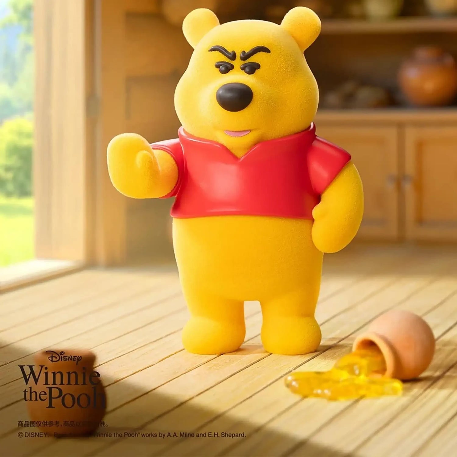 Yellow bear figure in a red shirt waving, with a small accessory on the floor
