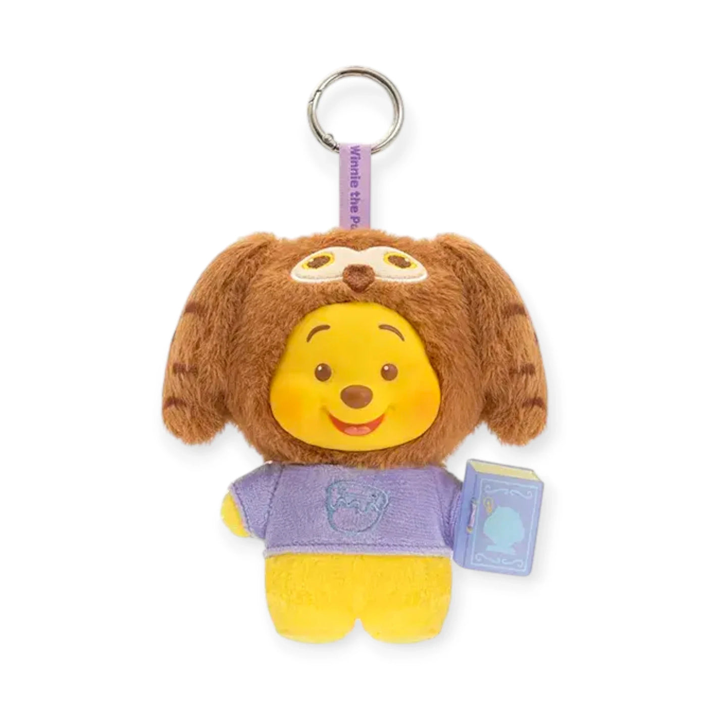 Brown teddy-eared plush keychain with Pooh face, purple shirt, and blue book tag.