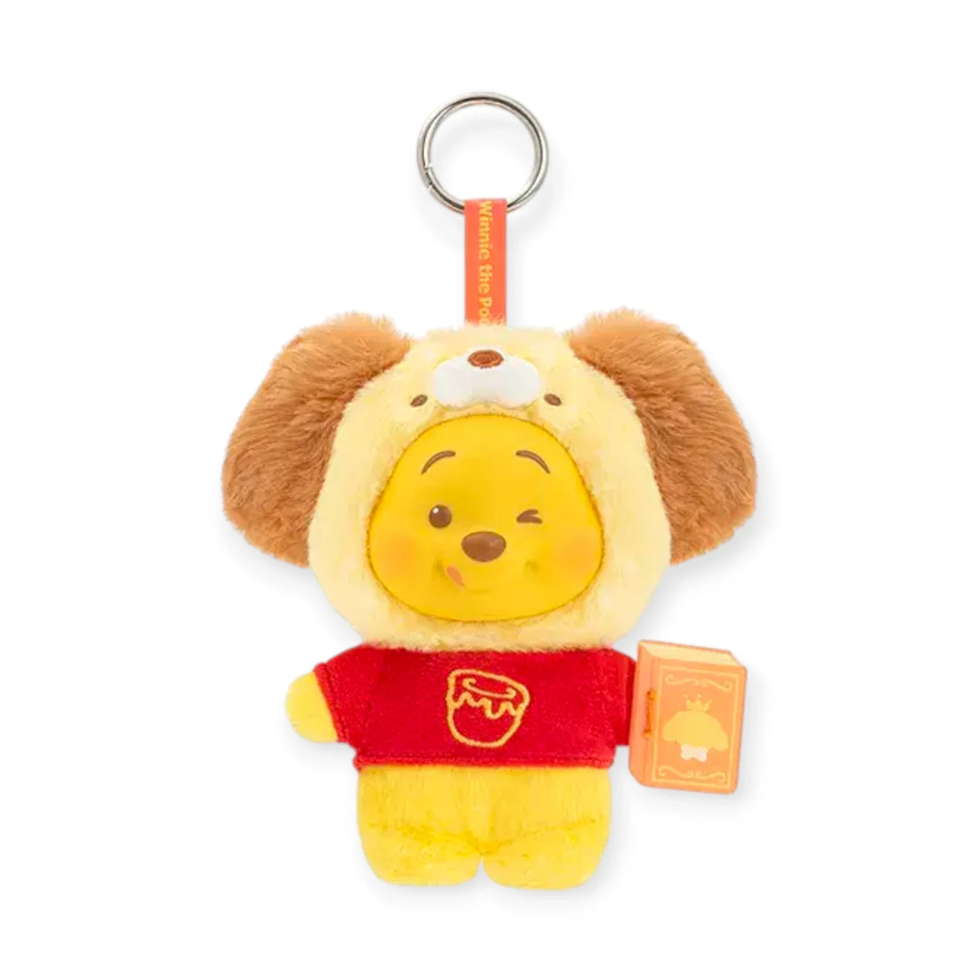 Brown puppy-eared plush keychain with Pooh face, red outfit, and orange book tag.