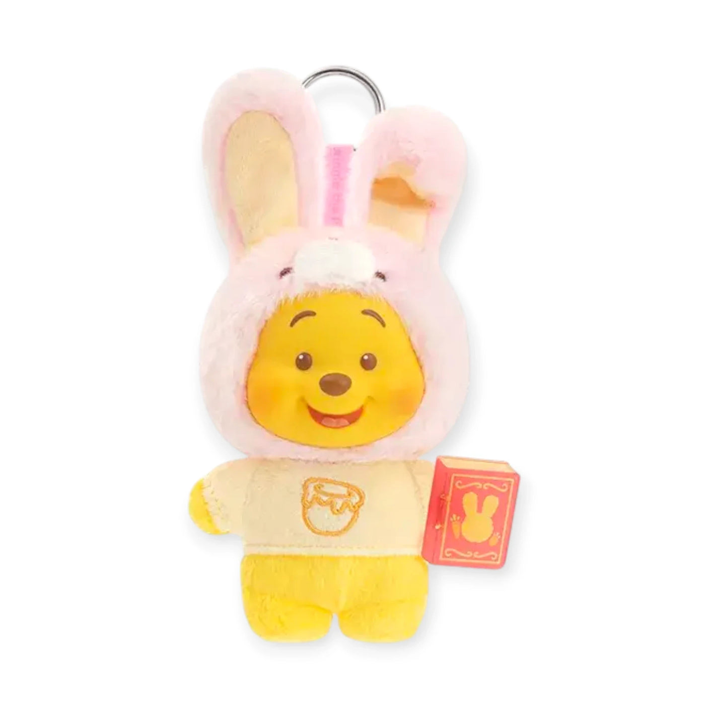 Pink bunny-eared plush keychain with Pooh face, yellow outfit, and orange book tag.