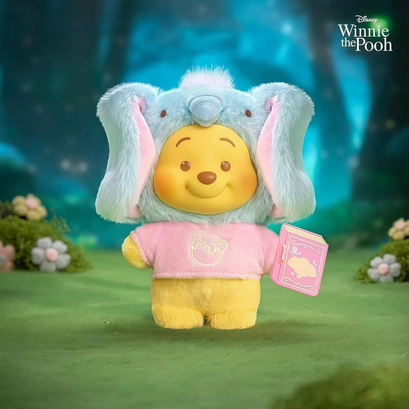 Light blue elephant-eared plush keychain with Pooh face, pink outfit, and pink book tag.