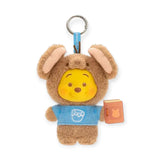Brown rabbit-eared plush keychain with Pooh face, blue outfit, and orange book tag.