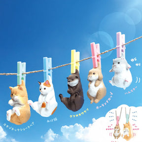 Yell's Washing Line Critters Charm Blind Box features five cute animal minifigure charms—cats, otter, rabbit, and hamster—dangling on a clothesline with colorful clothespins against a blue sky.