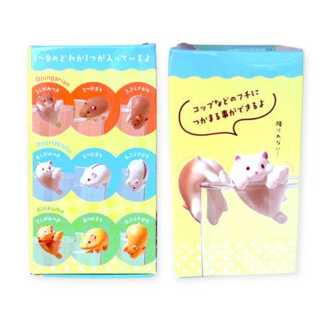 Two colorful boxes from Yell display Wobble Cup Hamster Blind Box figurines in playful poses, ideal as cute desk toys to clip onto cups or lids. Japanese text highlights the different types available.