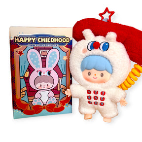 Small toy figure with blue hair dressed in fluffy white animal costume standing next to colorful bunny-themed box