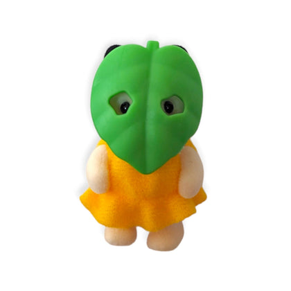 Green-faced plush figure wearing a yellow-orange dress with small white hands