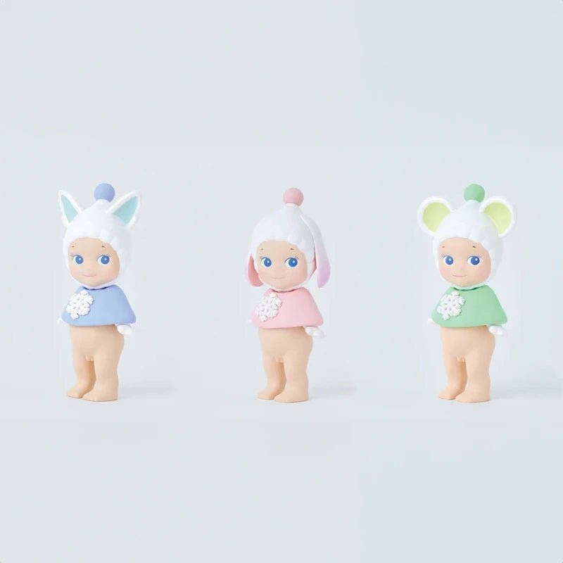 Three Sonny Angel Winter Wonderland mini figures standing in blue, pink, and green